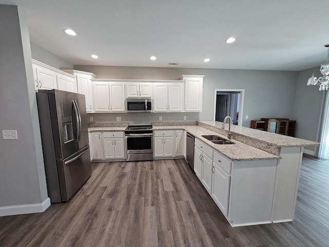 kitchen featuring kitchen peninsula, appliances with stainless steel finishes, and white cabinets