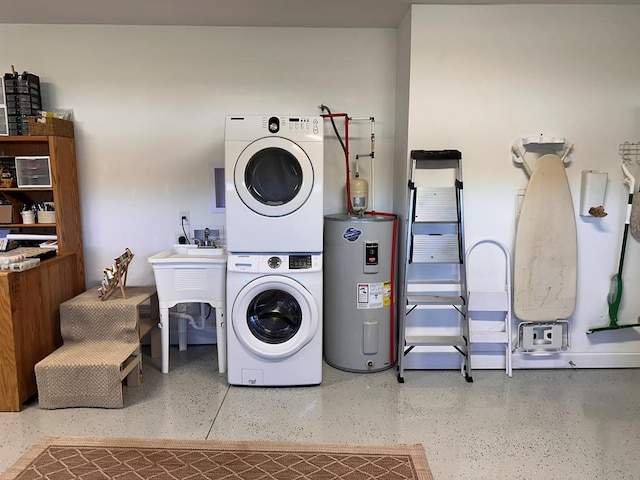 laundry area with electric water heater, stacked washer and clothes dryer, and sink