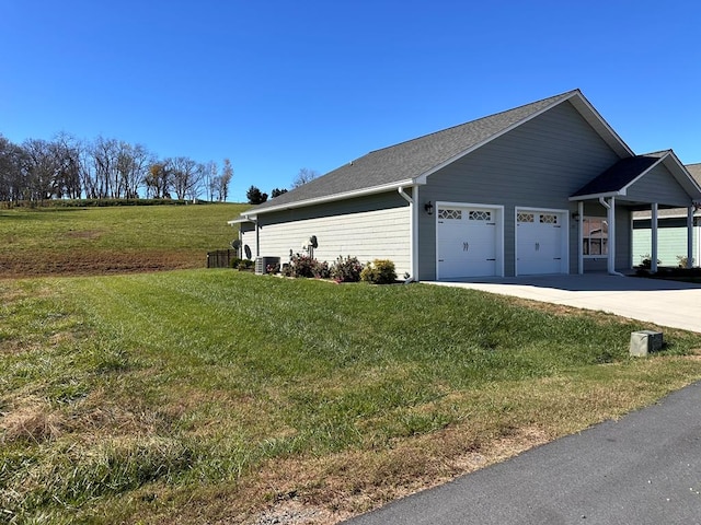 view of property exterior featuring a lawn, a garage, and central air condition unit