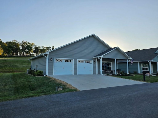 ranch-style home featuring central air condition unit, a yard, and a garage