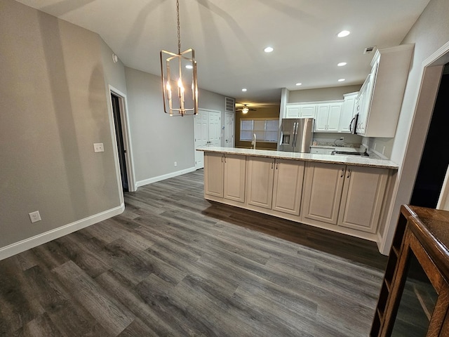 kitchen with kitchen peninsula, stainless steel fridge with ice dispenser, dark wood-type flooring, and decorative light fixtures