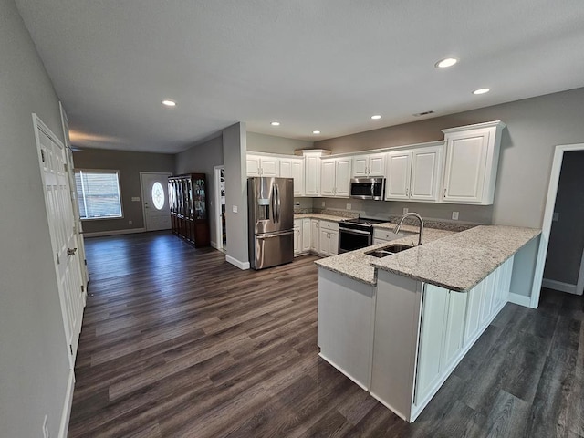 kitchen featuring kitchen peninsula, stainless steel appliances, sink, white cabinets, and dark hardwood / wood-style floors