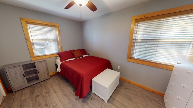 bedroom featuring ceiling fan, light wood-style flooring, and baseboards