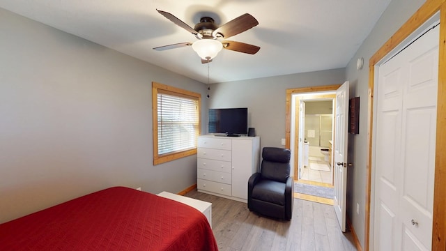 bedroom featuring baseboards, wood finished floors, a ceiling fan, and a closet