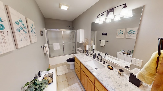 full bathroom with tile patterned floors, toilet, vanity, and shower / bath combination with glass door