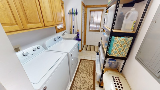 clothes washing area featuring light tile patterned flooring, separate washer and dryer, cabinet space, and a sink