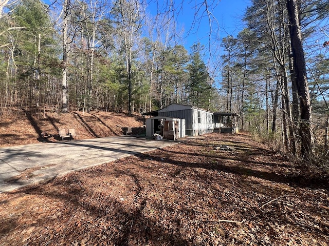 view of yard featuring driveway and a forest view