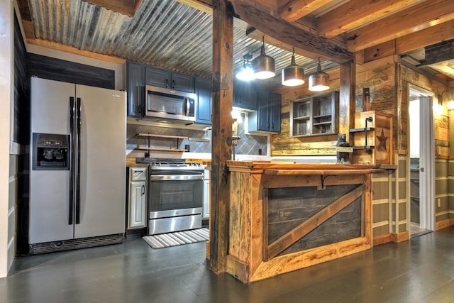 kitchen with blue cabinetry, appliances with stainless steel finishes, backsplash, beam ceiling, and wooden walls