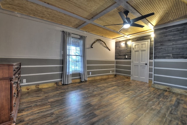 empty room with wood walls, wood ceiling, dark wood-type flooring, beamed ceiling, and ceiling fan