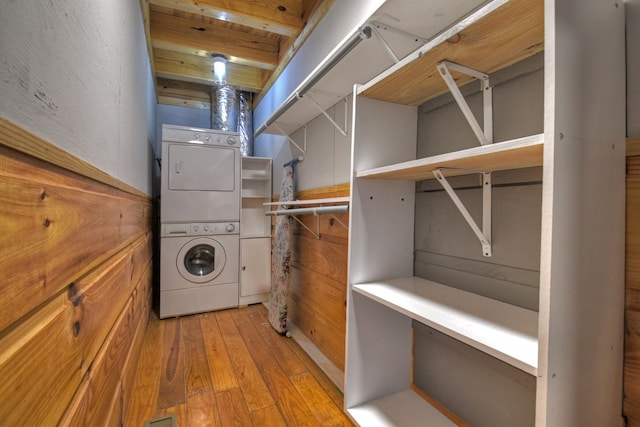 laundry area featuring light wood-type flooring and stacked washer / drying machine