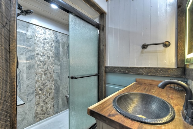 bathroom featuring a shower, wooden walls, and sink