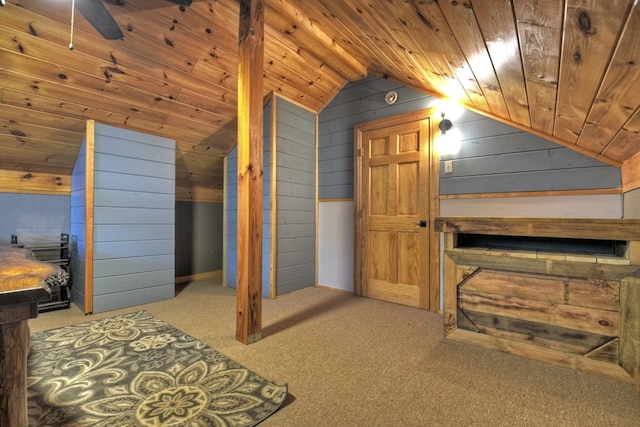 additional living space with wooden ceiling, wood walls, vaulted ceiling, light colored carpet, and ceiling fan