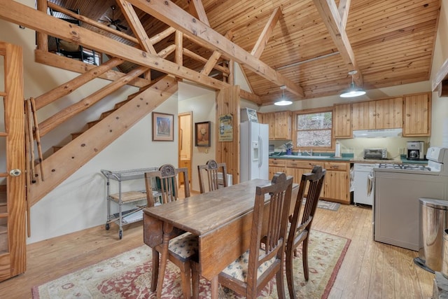 dining area featuring lofted ceiling with beams, light hardwood / wood-style floors, washer / dryer, and wooden ceiling