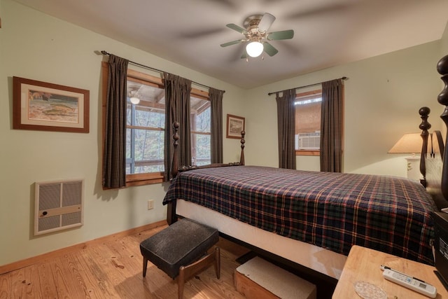 bedroom featuring light hardwood / wood-style flooring, cooling unit, ceiling fan, and heating unit