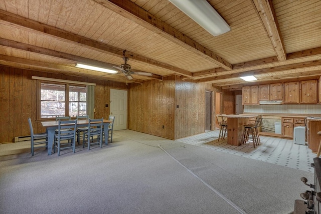 unfurnished dining area featuring beamed ceiling, ceiling fan, bar area, wood ceiling, and wooden walls