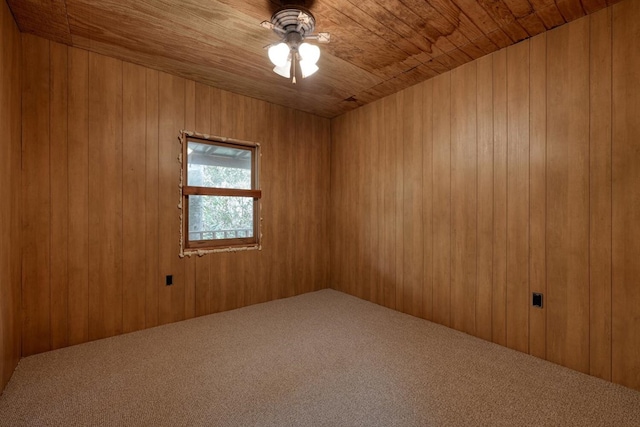 unfurnished room with carpet floors, wooden walls, ceiling fan, and wood ceiling