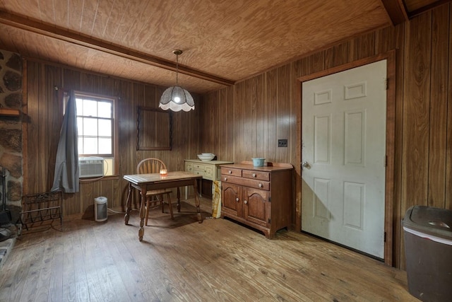 dining space featuring light wood-type flooring, wooden walls, wooden ceiling, and beam ceiling