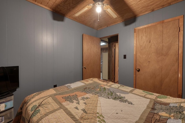 bedroom featuring ceiling fan, wood ceiling, and wooden walls