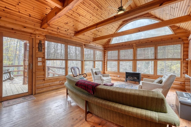 living room featuring wooden ceiling, a wood stove, vaulted ceiling with beams, and light hardwood / wood-style flooring