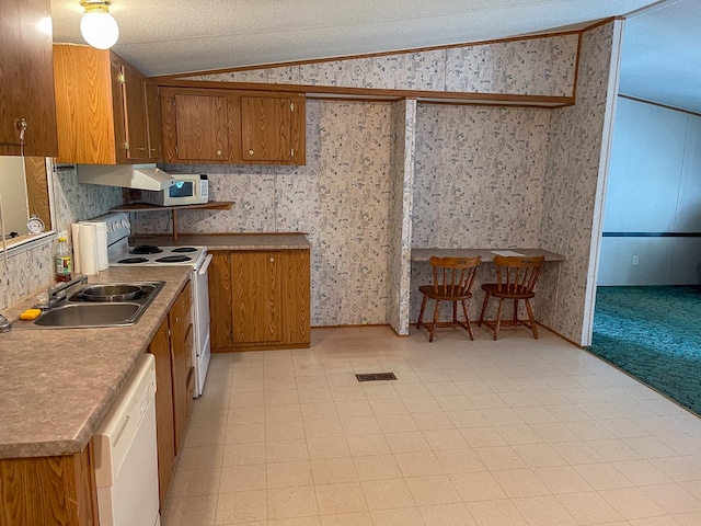 1716 Airport Rd, Marble, NC 28905 - kitchen with brown cabinets, white appliances, wallpapered walls, and vaulted ceiling