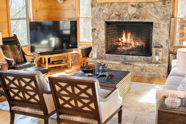 living room with wood-type flooring and a stone fireplace