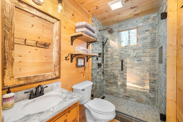 bathroom featuring vanity, a tile shower, wooden ceiling, and toilet