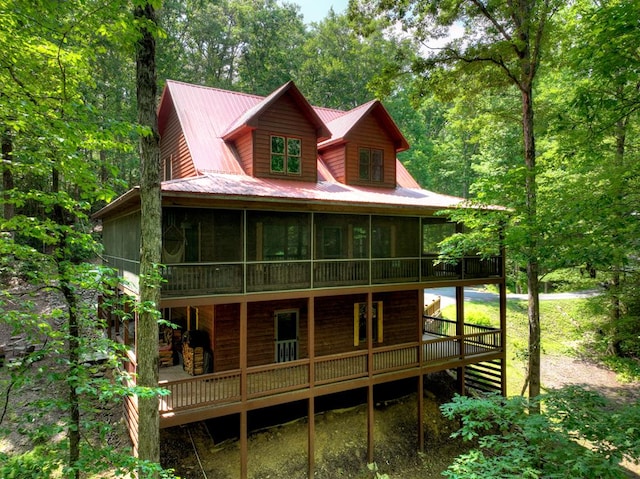 30 Okemah Ct, Ellijay, GA 30540 - view of front of house with a sunroom, a wooden deck, metal roof, and a view of trees
