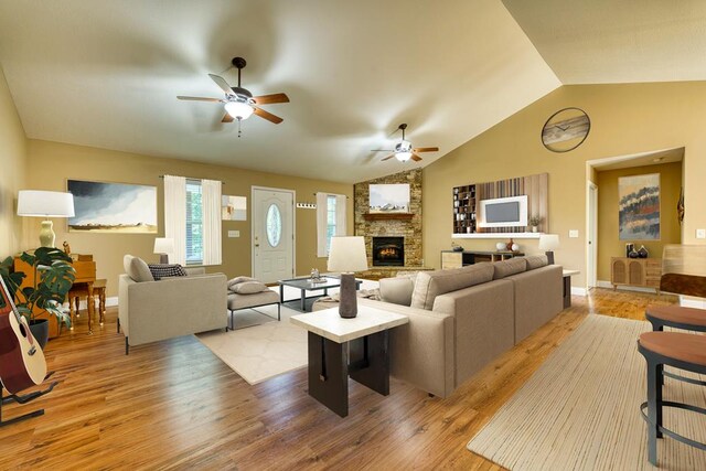 kitchen featuring vaulted ceiling, stainless steel refrigerator with ice dispenser, electric range, sink, and light wood-type flooring