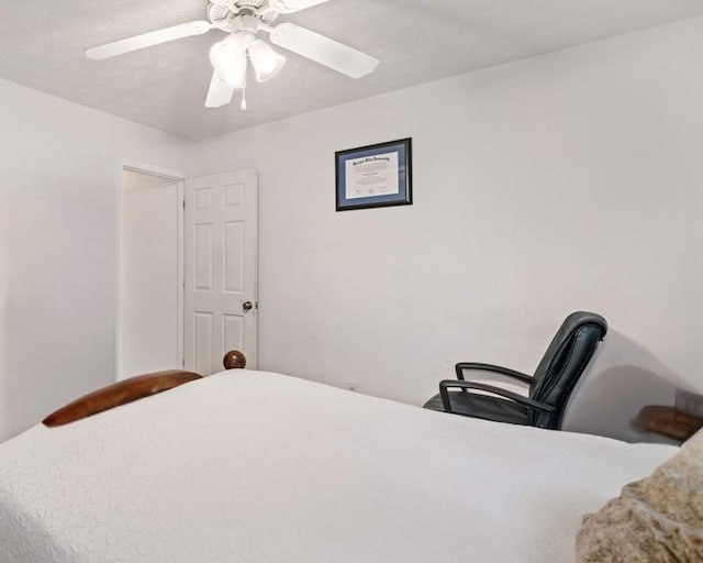 bedroom with ceiling fan and a textured ceiling