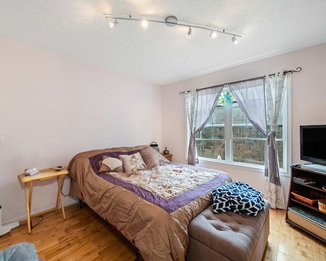 bedroom featuring a textured ceiling and light wood-type flooring