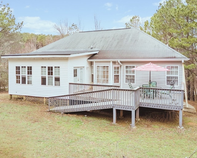 rear view of house with a yard and a deck