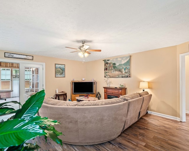 living room featuring ceiling fan, hardwood / wood-style floors, and a textured ceiling