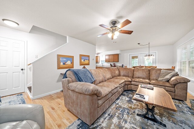 living room with ceiling fan, a textured ceiling, and light hardwood / wood-style flooring