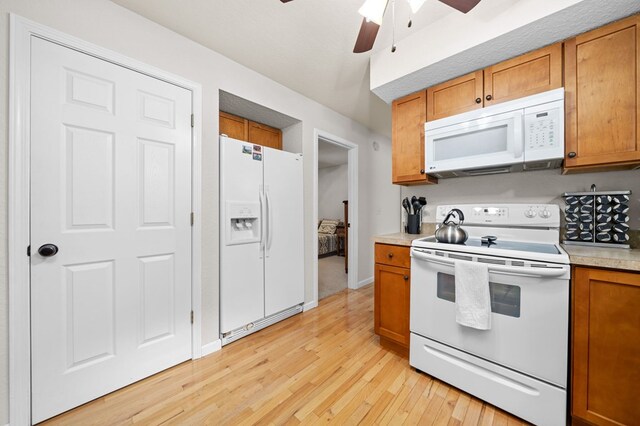 kitchen with light hardwood / wood-style floors, white appliances, and ceiling fan