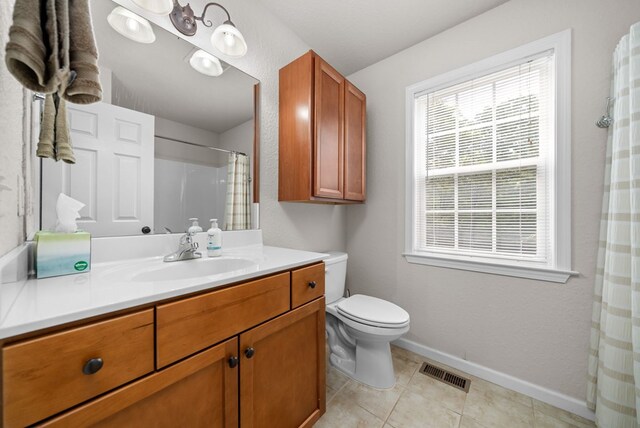 bathroom with vanity, tile patterned flooring, toilet, and curtained shower