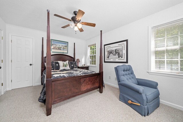 bedroom with ceiling fan, light colored carpet, and a textured ceiling