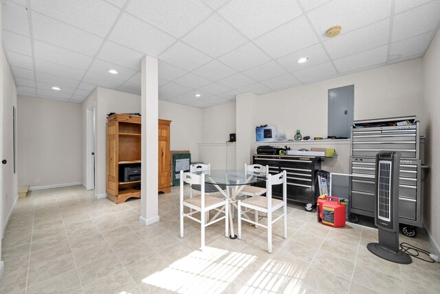 dining area with a paneled ceiling, light tile patterned flooring, and electric panel