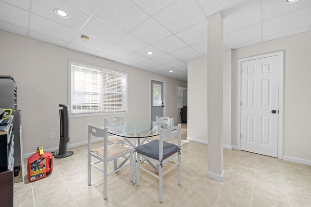 dining room featuring a drop ceiling and light tile patterned floors