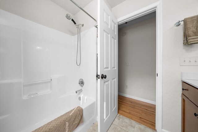 bathroom with  shower combination, hardwood / wood-style flooring, and vanity