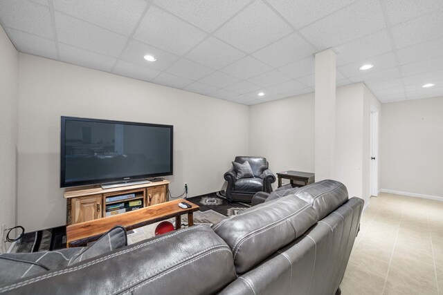 living room featuring a drop ceiling and tile patterned floors