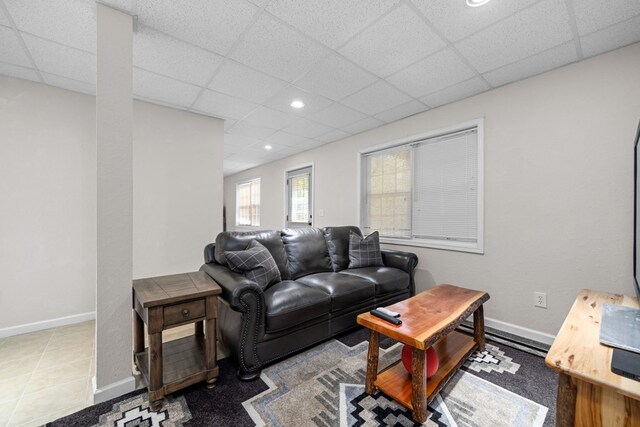 living room featuring a paneled ceiling and tile patterned flooring