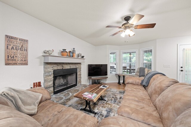 living room with ceiling fan, a stone fireplace, and hardwood / wood-style floors