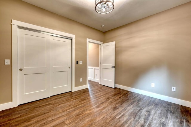 unfurnished bedroom with hardwood / wood-style floors and a closet