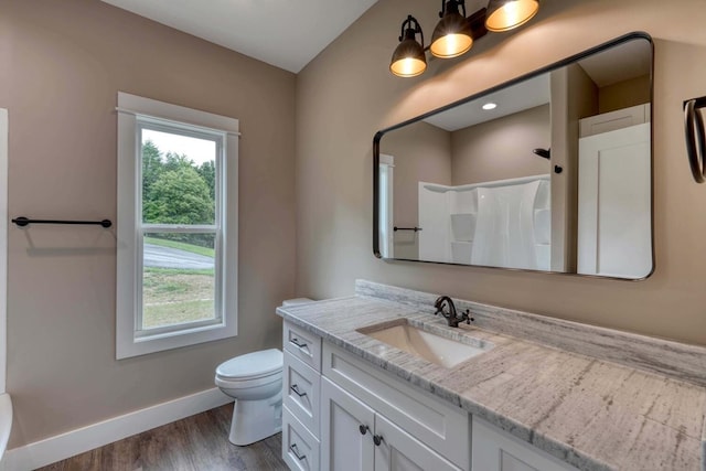 bathroom featuring walk in shower, vanity, toilet, and wood-type flooring