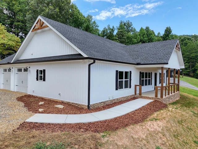 view of property exterior with a garage and covered porch