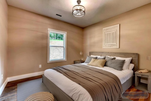 bedroom with dark hardwood / wood-style floors