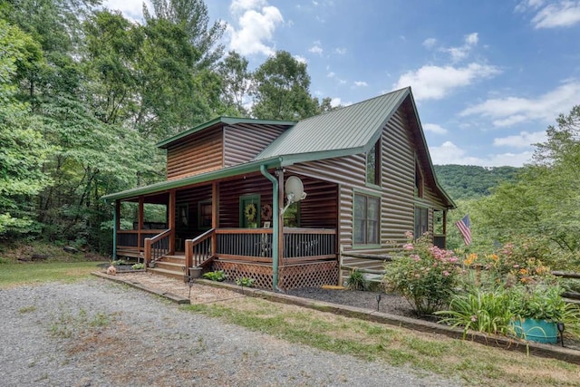 log cabin featuring covered porch