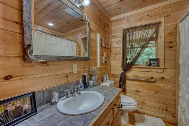 bathroom featuring wood walls, vanity, wooden ceiling, and toilet