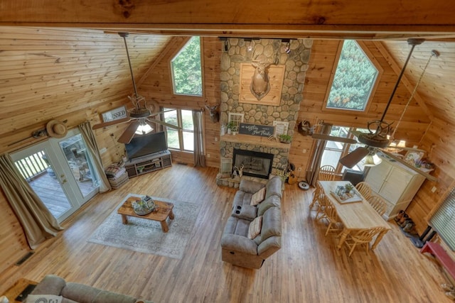 living room with hardwood / wood-style flooring, ceiling fan, a fireplace, and high vaulted ceiling