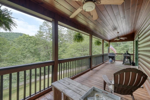 wooden deck with ceiling fan and a water view